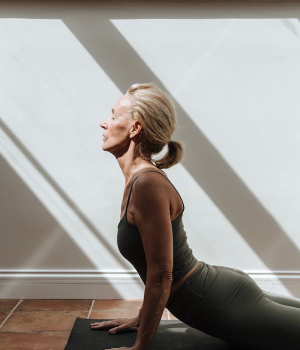 Woman performing a gentle stretching exercise in a calm environment.